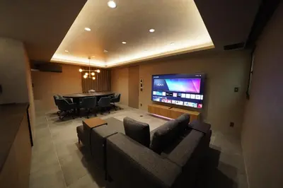 a living room with a couch and a tv and a table at Musashi Condo Takadanobaba in Tokyo