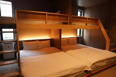 a bedroom with two bunk beds with white sheets at Musashi Condo Takadanobaba in Tokyo