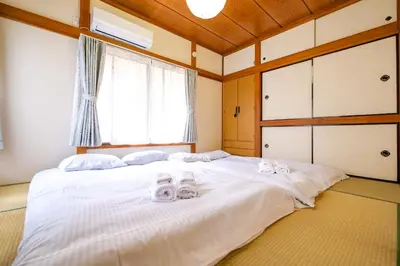 a bedroom with a large white bed with towels on it at Vivi Villa in Tokyo