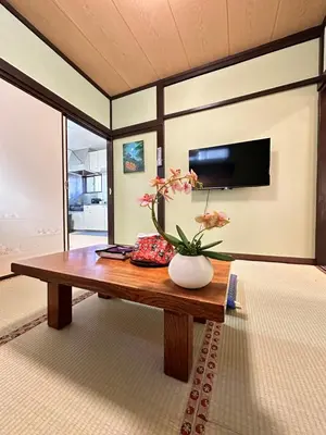 a room with a table with a vase of flowers on it at \u9752\u7825\u99c5\u5f92\u6b655\u5206 Aoto \u3060\u308b\u307e\u5bbf in Tokyo