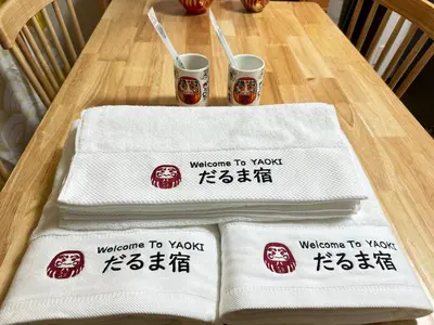 two white towels sitting on a table with drinks at \u9752\u7825\u99c5\u5f92\u6b655\u5206 Aoto \u3060\u308b\u307e\u5bbf in Tokyo