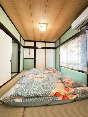 a large bed in a room with a wooden ceiling at \u9752\u7825\u99c5\u5f92\u6b655\u5206 Aoto \u3060\u308b\u307e\u5bbf in Tokyo