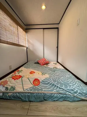 a bedroom with a bed with flowers on it at \u9752\u7825\u99c5\u5f92\u6b655\u5206 Aoto \u3060\u308b\u307e\u5bbf in Tokyo