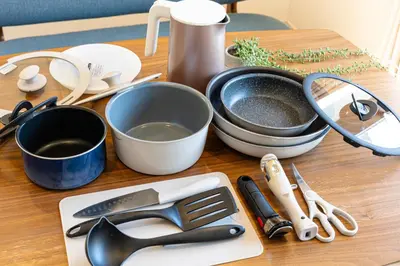 a table with cooking utensils on a wooden table at Four Trees Stay Yotsugi Skytree View in Tokyo
