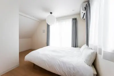 a white bed in a room with a window at Casa Stella Tokyo #3 Higashi Shinjuku in Tokyo