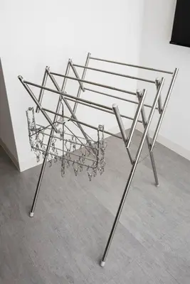 a metal bench in front of a white wall at Casa Stella Tokyo #3 Higashi Shinjuku in Tokyo