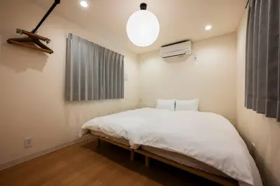 a bedroom with a large white bed and a window at Casa Stella Tokyo #3 Higashi Shinjuku in Tokyo