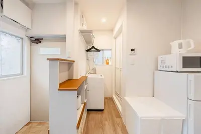 a white kitchen with a refrigerator and a microwave at Hotel SHIBA INU in Tokyo