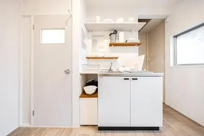 a white kitchen with a sink and a door at Hotel SHIBA INU in Tokyo