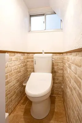 a white toilet in a bathroom with a window at Hotel SHIBA INU in Tokyo