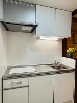 a kitchen with white cabinets and a sink at Lapis House 101 - 1F in Tokyo