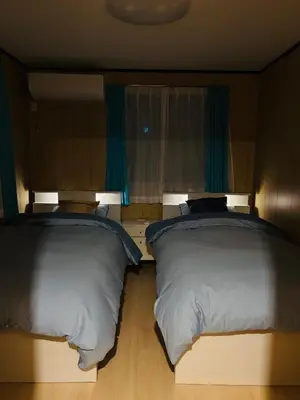 two beds sitting next to each other in a bedroom at Lapis House 101 - 1F in Tokyo