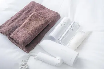 a towel and a bottle of lotion and a toothbrush at Midtown OIMACHI Hub in Tokyo