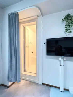 a room with a window and a television on a wall at Midtown OIMACHI Hub in Tokyo