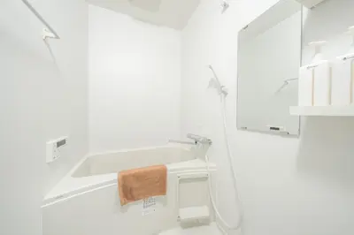 a white bathroom with a sink and a mirror at Midtown OIMACHI Hub in Tokyo