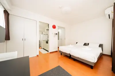 a white bedroom with a bed and a mirror at Kamata Opus2 Apartment in Tokyo