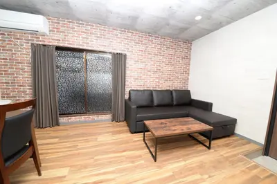 a living room with a black couch and a table at ACTResidence\u7b2c\u4e8c 4\u5ba41\u30d0\u30b9\u30eb\u30fc\u30e01\u30b7\u30e3\u30ef\u30fc3\u30c8\u30a4\u30ec in Tokyo