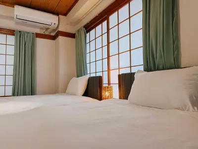 two beds in a room with large windows at Tokyo Shinjuku Waseda House\u65b0\u5bbf\u65e9\u7a32\u7530 in Tokyo