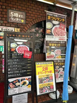 three signs in front of a restaurant with food at Tokyo Shinjuku Waseda House\u65b0\u5bbf\u65e9\u7a32\u7530 in Tokyo