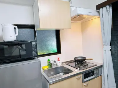 a small kitchen with a sink and a microwave at Tokyo Shinjuku Waseda House\u65b0\u5bbf\u65e9\u7a32\u7530 in Tokyo