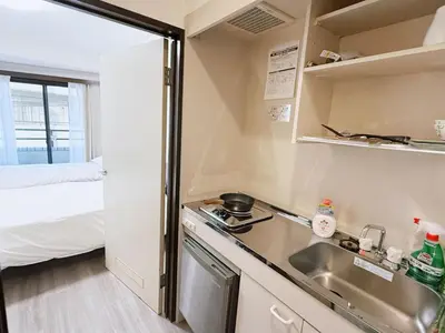 a small kitchen with a sink and a bed at Tokyo Shinjuku Waseda House\u65b0\u5bbf\u65e9\u7a32\u7530 in Tokyo