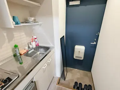 a small kitchen with a sink and a blue door at Tokyo Shinjuku Waseda House\u65b0\u5bbf\u65e9\u7a32\u7530 in Tokyo