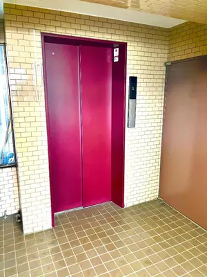a purple elevator door in a brick wall at Nr Ikebukuro! Room size 45m2! Free unlimited Wi-Fi! in Tokyo