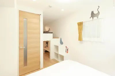 a room with a door and a cat on the wall at Gaia BOSCO by Tranova in Tokyo