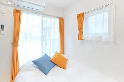 a bed with two pillows in front of a window at Gaia BOSCO by Tranova in Tokyo