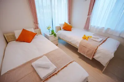 a room with two beds with orange and white at GH5286 Eight minutes to Akihabara Complete facilities and convenient location in Tokyo