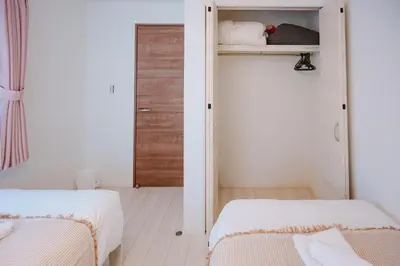 a small bedroom with two beds and a closet at GH5286 Eight minutes to Akihabara Complete facilities and convenient location in Tokyo