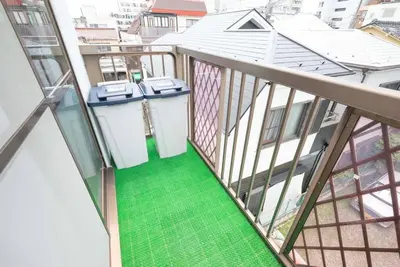 a balcony with a green floor in a building at \u30a2\u30f3\u30c9\u30b9\u30c6\u30a4\u304a\u82b1\u8336\u5c4b1\u4e01\u76ee301 in Tokyo