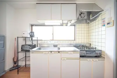 a kitchen with white cabinets and a sink at \u30a2\u30f3\u30c9\u30b9\u30c6\u30a4\u304a\u82b1\u8336\u5c4b1\u4e01\u76ee301 in Tokyo
