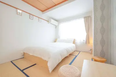 a white bedroom with a large bed and a window at \u30a2\u30f3\u30c9\u30b9\u30c6\u30a4\u304a\u82b1\u8336\u5c4b1\u4e01\u76ee301 in Tokyo