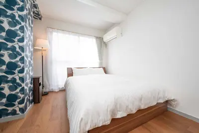 a bedroom with a white bed and a window at \u30a2\u30f3\u30c9\u30b9\u30c6\u30a4\u304a\u82b1\u8336\u5c4b1\u4e01\u76ee301 in Tokyo