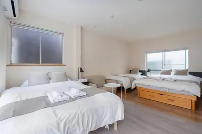 three beds in a room with white walls at \u30a2\u30f3\u30c9\u30b9\u30c6\u30a4\u5927\u68ee\u897f2\u4e01\u76ee in Tokyo
