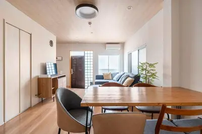 a living room with a wooden table and chairs at \u30a2\u30f3\u30c9\u30b9\u30c6\u30a4\u5927\u68ee\u897f2\u4e01\u76ee in Tokyo