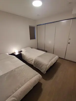 a bedroom with two beds and a closet at \u30e9\u30d1\u30f3\u30a2\u30b8\u30eb in Tokyo