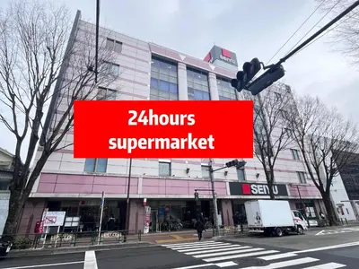 a red sign that reads hourssupermarket in front of a building at ToyamaHouse2-202 in Tokyo