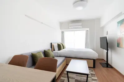 a living room with a bed and a couch at GRAN PASEo\u9ad8\u5186\u5bfa\u5357 in Tokyo