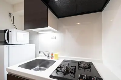 a kitchen with a stove top oven next to a sink at GRAN PASEo\u9ad8\u5186\u5bfa\u5357 in Tokyo