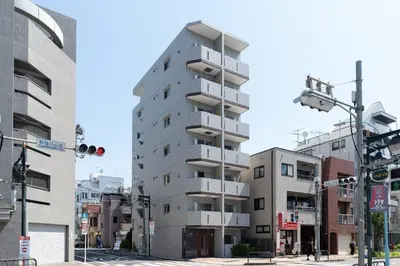 a tall grey building with balconies on a city street at GRAN PASEo\u9ad8\u5186\u5bfa\u5357 in Tokyo