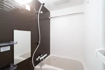 a shower in a bathroom with a black wall at GRAN PASEo\u9ad8\u5186\u5bfa\u5357 in Tokyo