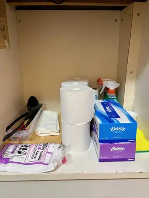 a shelf with a stack of toilet paper and a box at Mori house ookubobiru in Tokyo