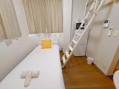a small room with a bunk bed and a ladder at Mori house ookubobiru in Tokyo
