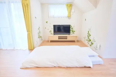 a white bedroom with a bed and a tv at Sunny Court by Tranova in Tokyo