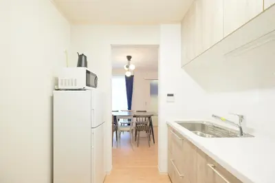 a kitchen with a white refrigerator and a table at Sunny Court by Tranova in Tokyo