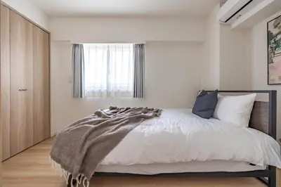 a bedroom with a bed with a blanket on it at Dash Living Asakusa East in Tokyo