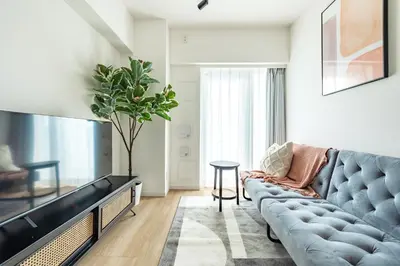 a living room with a blue couch and a tv at Dash Living Asakusa East in Tokyo