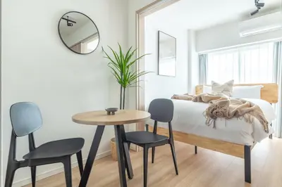 a bedroom with a bed and a table and chairs at Dash Living Asakusa East in Tokyo